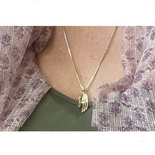 collier doré avec main porte bonheur