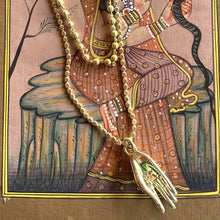 collier doré avec main porte bonheur